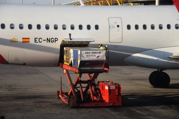Carga de equipaje en un avión estacionado en los asfaltos del aeropuerto internacional de Madrid — Foto de Stock