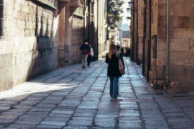 Üniversite yakınlarındaki Salamanca 'nın eski sokağında yürüyen genç bir öğrenci.