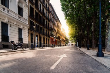 Madrid 'in merkezindeki boş cadde sabahın erken saatlerinde güneş ışığıyla aydınlanıyor.