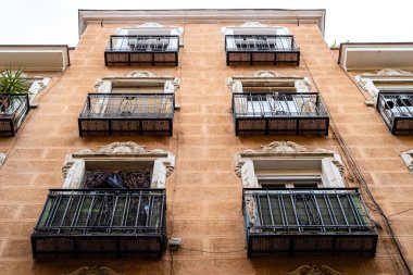 Madrid 'deki Lavapies Mahallesi' nde eski bir binanın eski demir balkonlarının alçak açılı görüntüsü.