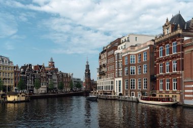 Amsterdam, Hollanda - 7 Mayıs 2022: Amsterdam şehir merkezindeki Amstel Nehri manzaralı. Tipik ve lüks Hollandalı evleri