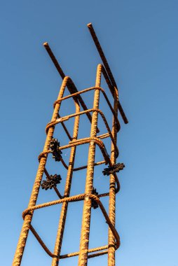 Sütun demirleri gökyüzüne karşı. Beton yapı için çelik güçlendirme çubukları olan inşaat alanı