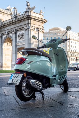 Madrid, Spain - October 3, 2020: Vespa scooter against Alcala Gate monument