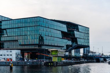 Amsterdam, Hollanda - 6 Mayıs 2022: Yeni lüks yerleşim ve ticari gelişmelerle birlikte kanalın rıhtım manzarası