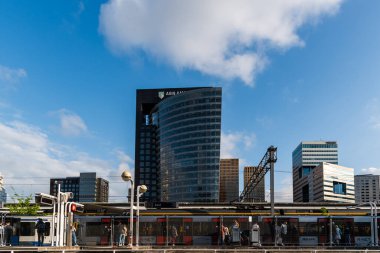 Amsterdam, Hollanda - 7 Mayıs 2022: ABN Amro Bank gökdeleni ve Amsterdam Zuid istasyonu. Çağdaş mimari, mavi renkler. Düşük açı görünümü