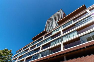 Rotterdam, Hollanda - 8 Mayıs 2022: Meuse Nehri 'nin kıyısında yeni bir apartman. Gökyüzüne karşı alçak açı görünümü