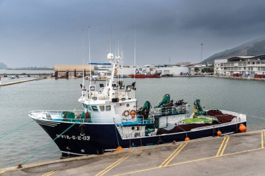 Santona, İspanya - 13 Ağustos 2022: Bulutlu bir günde balıkçı tekneli liman. Santona ançüez konserve endüstrisi ile ünlüdür.