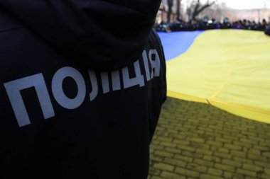 Ukrayna polisi, Ukrayna bayrağının arka planında Ukraynaca yazılmış yazı: Polis