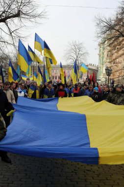 Odessa, Ukrayna Şubat, 20.2022 Ukrayna bayraklarına sarılmış insanlar Birleşme Yürüyüşünde Ukrayna bayrağını taşıyor
