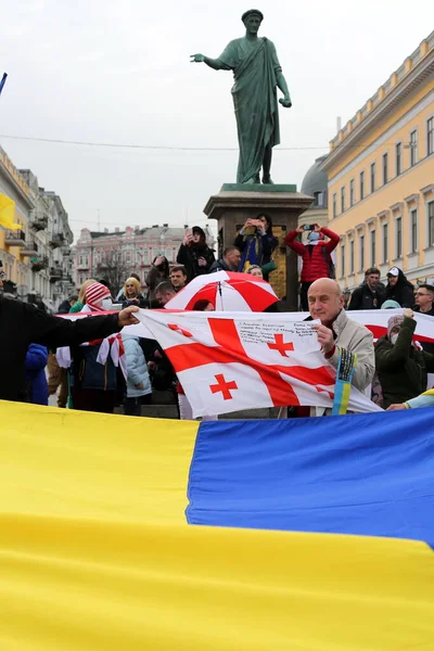 ウクライナのオデッサ2022年2月2日人々は彼らの手にウクライナの大きな旗を保持し 他の人々はデ リシュリュー公爵への記念碑の背景にジョージアの旗を保持します ロイヤリティフリーのストック写真