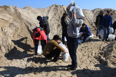 Odessa, Ukrayna 16 Mart 2022 'de Odessa sakinleri kendilerini organize ederek şehir plajından gelen kum torbalarını doldurdular. Çantalar Odessa, Ukrayna sokaklarındaki stratejik noktaları ve barikatları korumak için kullanılacak..