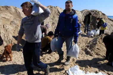 Odessa, Ukrayna 16 Mart 2022 'de Odessa sakinleri kendilerini organize ederek şehir plajından gelen kum torbalarını doldurdular. Çantalar Odessa, Ukrayna sokaklarındaki stratejik noktaları ve barikatları korumak için kullanılacak..