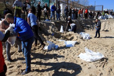 Odessa, Ukrayna 16 Mart 2022 'de Odessa sakinleri kendilerini organize ederek şehir plajından gelen kum torbalarını doldurdular. Çantalar Odessa, Ukrayna sokaklarındaki stratejik noktaları ve barikatları korumak için kullanılacak..