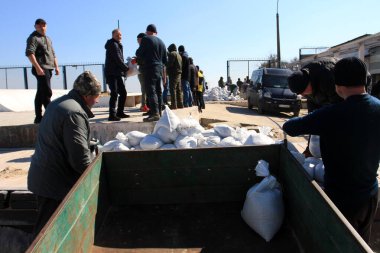 Odessa, Ukrayna 16 Mart 2022 'de Odessa sakinleri kendilerini organize ederek şehir plajından gelen kum torbalarını doldurdular. Çantalar Odessa, Ukrayna sokaklarındaki stratejik noktaları ve barikatları korumak için kullanılacak..