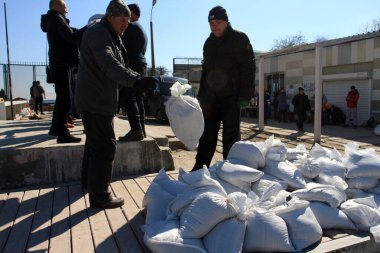 Odessa, Ukrayna 16 Mart 2022 'de Odessa sakinleri kendilerini organize ederek şehir plajından gelen kum torbalarını doldurdular. Çantalar Odessa, Ukrayna sokaklarındaki stratejik noktaları ve barikatları korumak için kullanılacak..