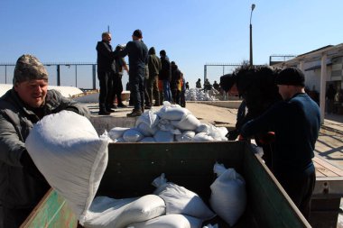 Odessa, Ukrayna 16 Mart 2022 'de Odessa sakinleri kendilerini organize ederek şehir plajından gelen kum torbalarını doldurdular. Çantalar Odessa, Ukrayna sokaklarındaki stratejik noktaları ve barikatları korumak için kullanılacak..