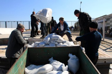 Odessa, Ukrayna 16 Mart 2022 'de Odessa sakinleri kendilerini organize ederek şehir plajından gelen kum torbalarını doldurdular. Çantalar Odessa, Ukrayna sokaklarındaki stratejik noktaları ve barikatları korumak için kullanılacak..