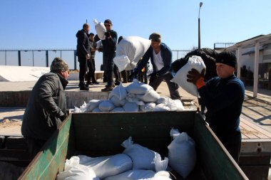 Odessa, Ukrayna 16 Mart 2022 'de Odessa sakinleri kendilerini organize ederek şehir plajından gelen kum torbalarını doldurdular. Çantalar Odessa, Ukrayna sokaklarındaki stratejik noktaları ve barikatları korumak için kullanılacak..