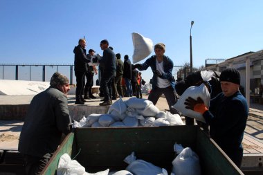 Odessa, Ukrayna 16 Mart 2022 'de Odessa sakinleri kendilerini organize ederek şehir plajından gelen kum torbalarını doldurdular. Çantalar Odessa, Ukrayna sokaklarındaki stratejik noktaları ve barikatları korumak için kullanılacak..