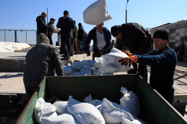 Odessa, Ukrayna 16 Mart 2022 'de Odessa sakinleri kendilerini organize ederek şehir plajından gelen kum torbalarını doldurdular. Çantalar Odessa, Ukrayna sokaklarındaki stratejik noktaları ve barikatları korumak için kullanılacak..
