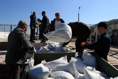 Odessa, Ukrayna 16 Mart 2022 'de Odessa sakinleri kendilerini organize ederek şehir plajından gelen kum torbalarını doldurdular. Çantalar Odessa, Ukrayna sokaklarındaki stratejik noktaları ve barikatları korumak için kullanılacak..