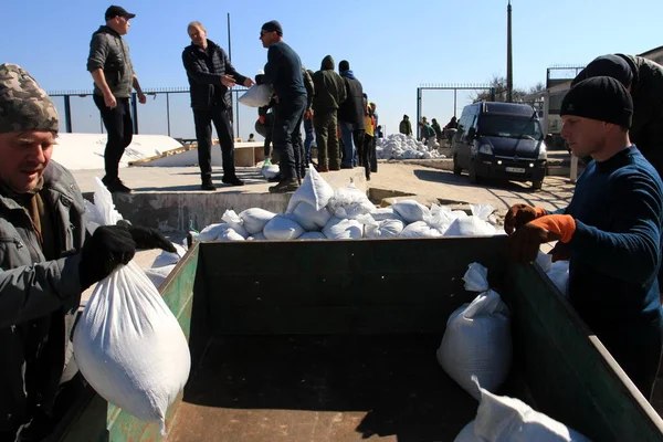 Odessa, Ukrayna 16 Mart 2022 'de Odessa sakinleri kendilerini organize ederek şehir plajından gelen kum torbalarını doldurdular. Çantalar Odessa, Ukrayna sokaklarındaki stratejik noktaları ve barikatları korumak için kullanılacak..