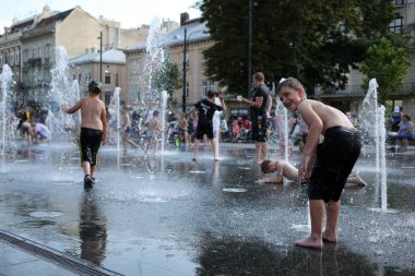 Lviv, Ukraine,June 30, 2022.Children bathe in the fountain near the building of the Lviv National Academic Opera and Ballet Theater named after Solomiya Krushelnytska