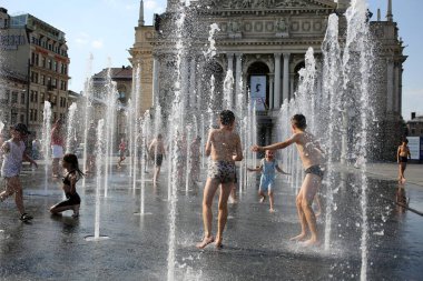 Lviv, Ukraine,June 30, 2022.Children bathe in the fountain near the building of the Lviv National Academic Opera and Ballet Theater named after Solomiya Krushelnytska