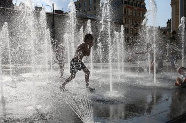Lviv, Ukraine,June 30, 2022.Children bathe in the fountain near the building of the Lviv National Academic Opera and Ballet Theater named after Solomiya Krushelnytska
