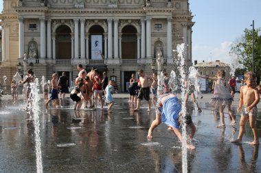 Lviv, Ukraine,June 30, 2022.Children bathe in the fountain near the building of the Lviv National Academic Opera and Ballet Theater named after Solomiya Krushelnytska.