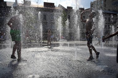 Lviv, Ukraine,30, June, 2022 Children bathe in a fountain near the building Lviv National Academic Opera and Ballet named after Solomia Krushelnitskaya