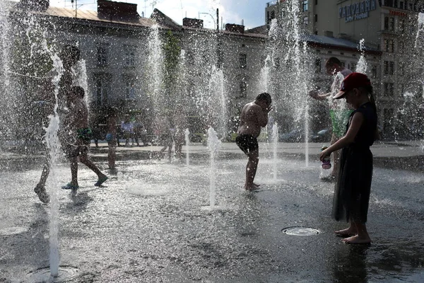 2022年6月30日 乌克兰利沃夫 孩子们在利沃夫国家学术歌剧和芭蕾舞团大楼附近的一个喷泉中洗澡 这个喷泉是以Solomia Krushelnitskaya命名的 — 图库照片