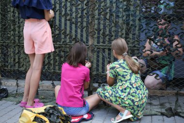 Odessa, Ukraine July 31, 2022 .Children and adults knit protective camouflage nets.