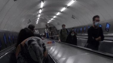 Londra 'daki Victoria İstasyonu' nda yürüyen merdivende dikiliyorum.