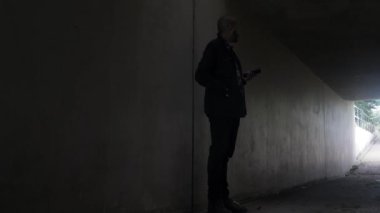 Gölgeli Kel Etnik Azınlık Alt Geçit Tüneli 'nde Mobil Bekleme Kılavuzu. Yan yana bakıyoruz. Kilitli, Düşük Açı