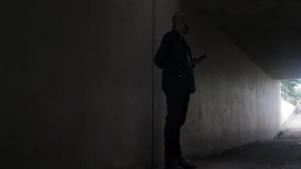 Shady Bald Ethnic Minority Checking Mobile Waiting Underpass Tunnel Van — Stockvideo