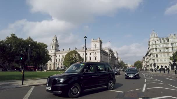 웨스트민스터에 아름다운 건축물로 둘러싸여 도시에서 인기있는 전통적 택시는 광장에서 정차하고 — 비디오