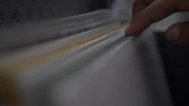 Bir DJ 'in, plak kutusunun kapağını açıp albüm koleksiyonunu gözler önüne sererken ve sevdiği parçayı ararken yakın plan çekimleri.