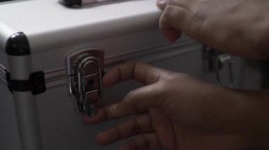 Müzik işi sırasında metal kutusunun kapağını açıp tercih ettiği plağı ararken bir DJ 'in ellerini yakından çek.