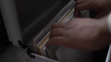 Bir DJ 'in müzik koleksiyonunu ararken yakın plan bir sonraki şarkısı için düşündüğü albümü bulmaya çalışırken.
