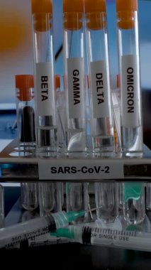 SARS COV 2 Test Tubes Labelled Alpha Gamma Delta Beta And Omicron Variants Being Removed From Rack. Vertical Video, Locked Off