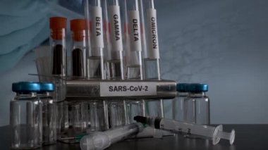 Test tubes labelled with variants of Covid 19 are being removed from the rack in the laboratory.