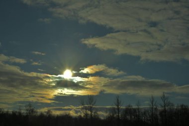 Güneş ışınları tarlanın üzerindeki bulutlardan geliyor.