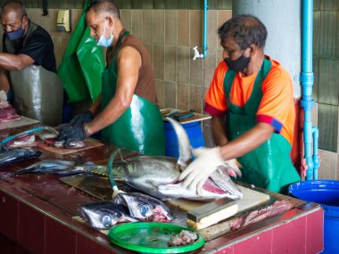 Maldivler balıkçısı yerel bir markette deniz ürünleri hazırlıyor.
