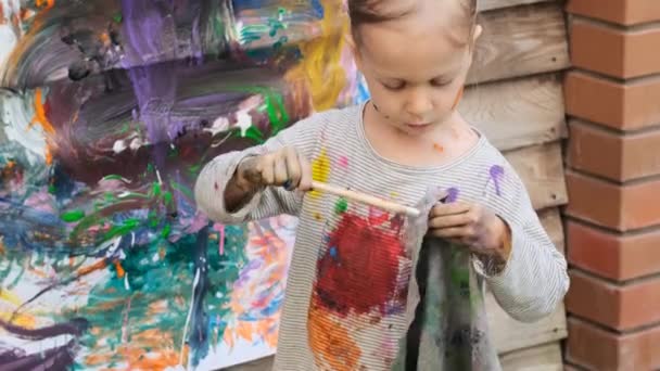 Menina limpa escova com um pano depois de pintar — Vídeo de Stock