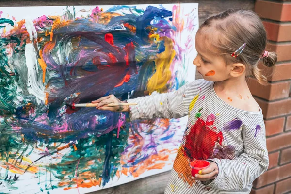 Schattig klein meisje vinger schilderen met verschillende kleuren — Stockfoto