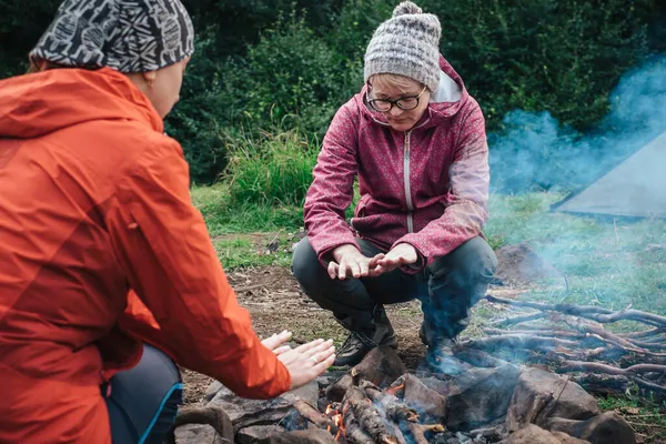 Amigos viajando juntos e desfrutar de fogueira de coração no acampamento — Fotografia de Stock