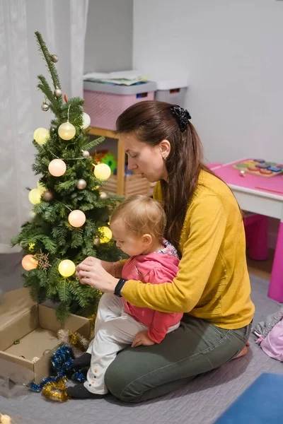 Mom and daughter decorate the Christmas tree at home — Stock Photo, Image