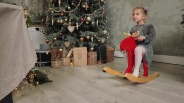 Mutlu bayramlar, Noel ağacının yanında oynayan küçük kız. 