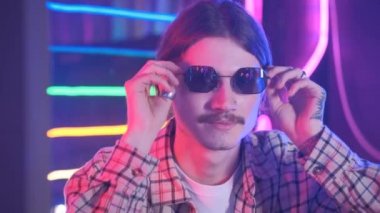 Güneş gözlüklü ve neon retro tarzlı bin yıllık bir adamın portresi